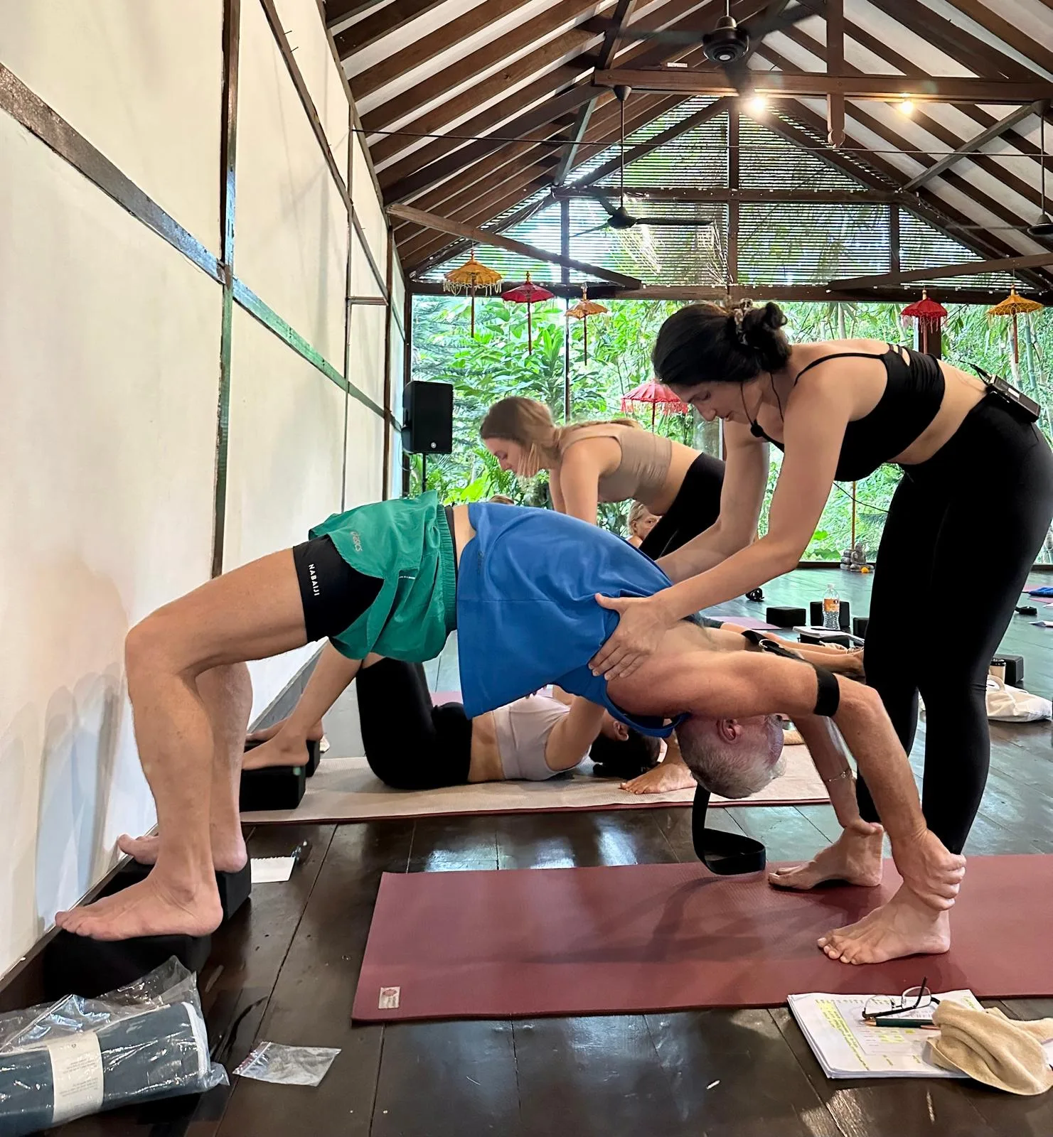 Amira assisting a student in a backbend during a yoga workshop